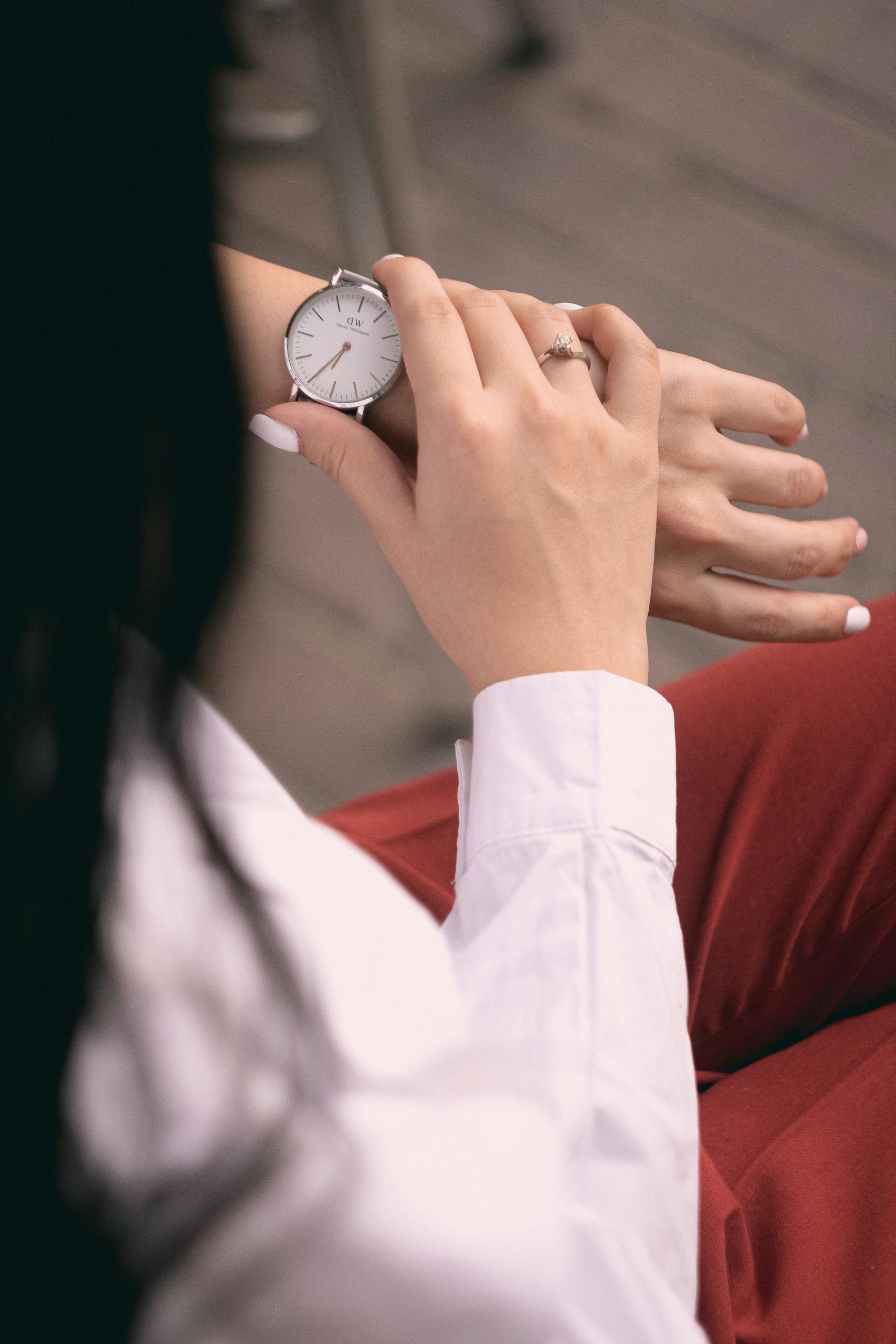 Adult woman with casual clothing checking time on wristwatch.
